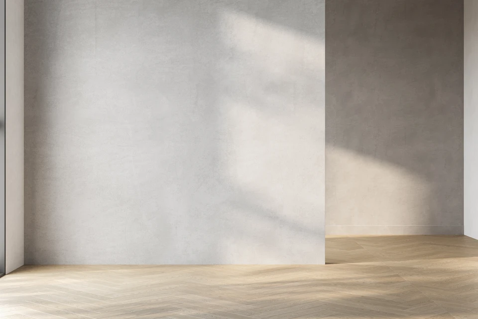 Une grande pièce vide avec un mur blanc et une fenêtre