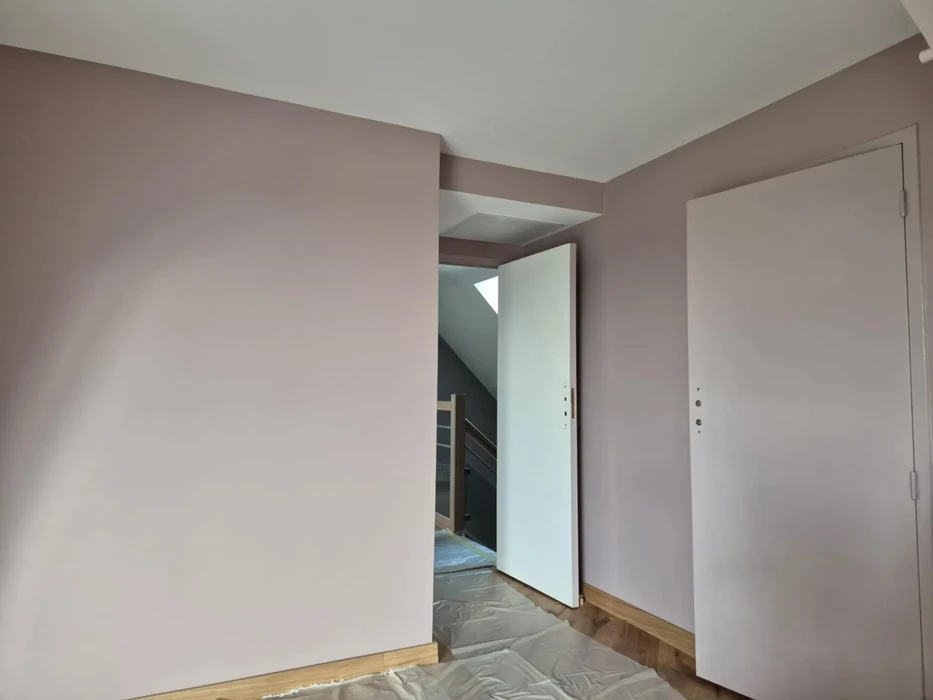 Pièce intérieure en cours de rénovation avec murs fraîchement peints en rose poudré