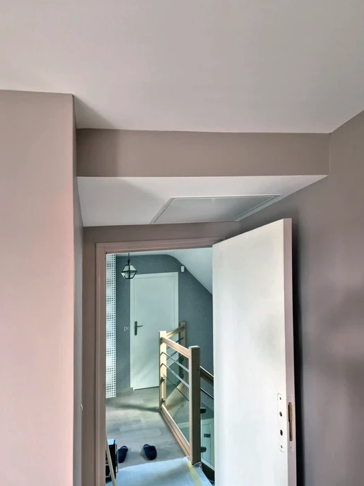 Intérieur résidentiel en cours de finition avec escalier moderne à garde-corps métallique