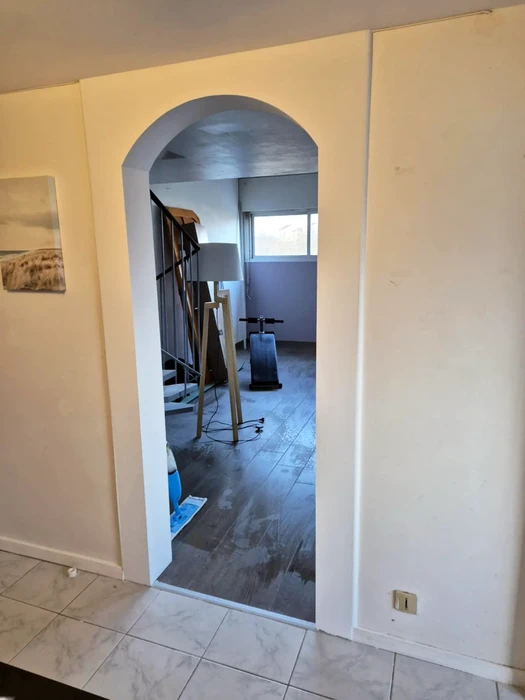 Intérieur d'habitation en cours de rénovation avec artisan travaillant