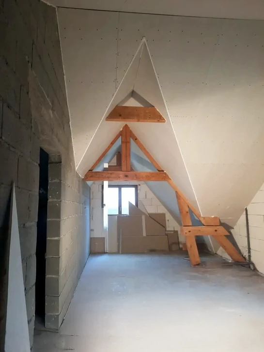 Chantier de construction avec outils de ma&ccedil;onnerie dispos&eacute;s contre un mur en b&eacute;ton brut